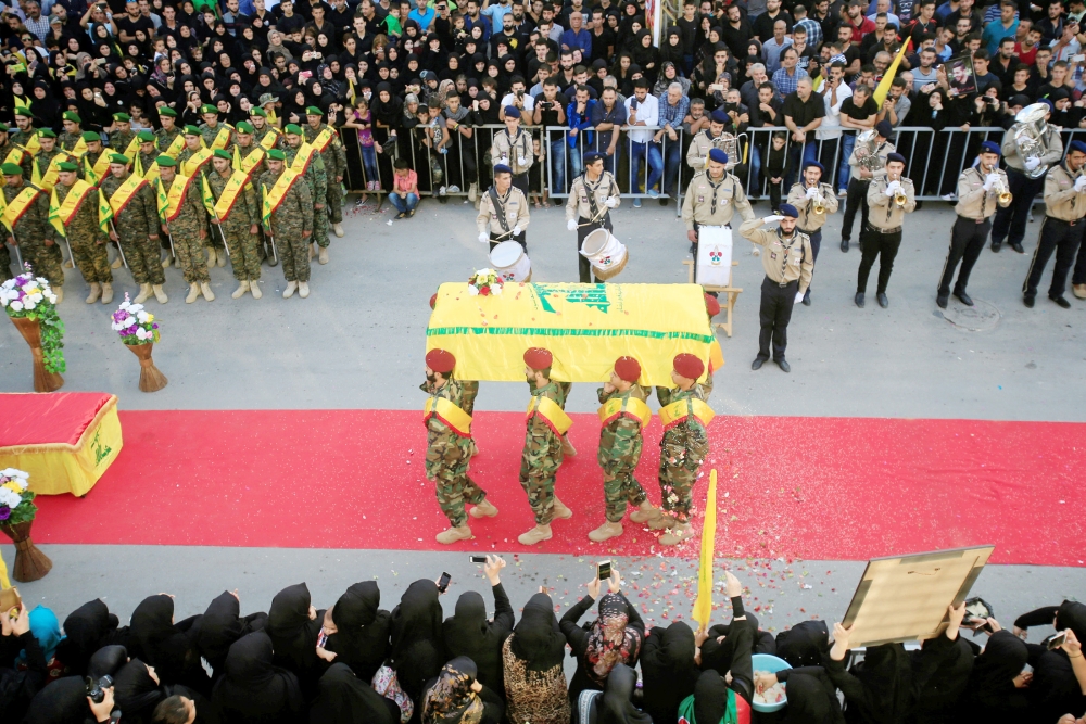 Men carry the coffin of Hezbollah fighter Mohamad al-Shami, who was killed during clashes in Syria's Aleppo, during his funeral in Bisariye village, southern Lebanon October 24, 2016. REUTERS/Ali Hashisho