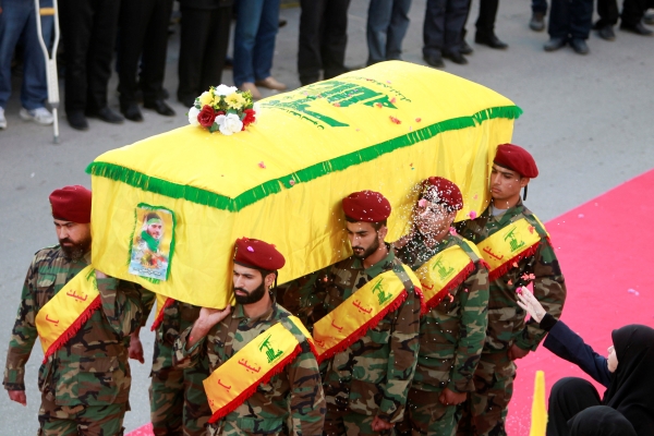 A woman throws rice as men carry the coffin of Hezbollah fighter Mohamad al-Shami, who was killed during clashes in Syria's Aleppo, during his funeral in Bisariye village, southern Lebanon October 24, 2016. REUTERS/Ali Hashisho