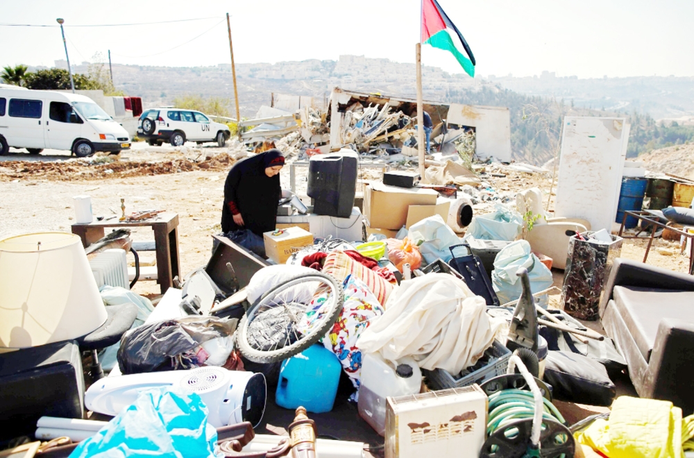  فلسطينية تبحث عن أمتعتها بعد هدم الاحتلال منزل عائلتها قرب بيت حنينا. (أ ف ب)