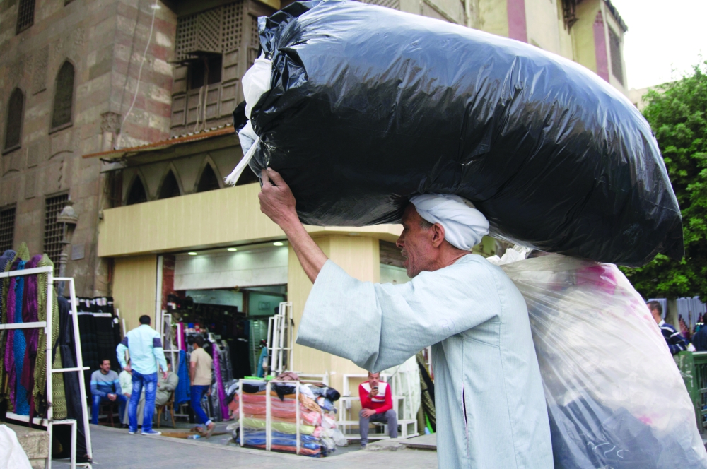 An Egyptian street vendor walks on El-Moez Street in Fatimid Cairo, Egypt, Friday, Nov. 11, 2016. The government has floated the local currency and raised fuel prices in order to qualify for a $12 billion bailout loan from the International Monetary Fund. These reforms have earned praise from the IMF and the international business community, but they have also spawned rising prices and costs of living for an already frustrated Egyptian population and President Abdel-Fattah el-Sissi risks a serious political backlash. (AP Photo/Amr Nabil)