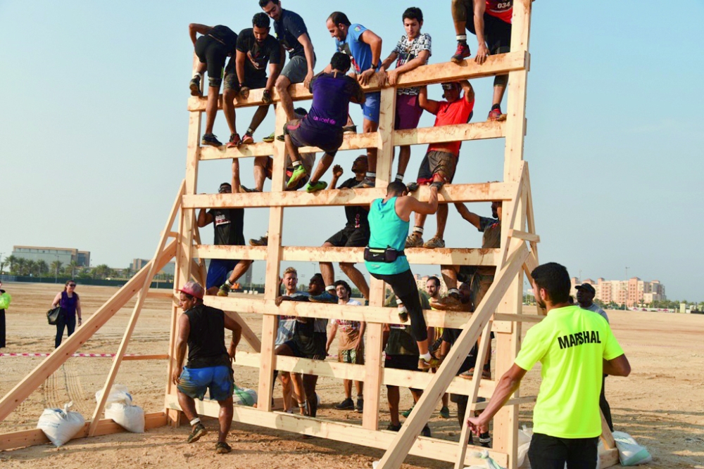 عدد من المتسابقين في محاولة تجاوز حاجز البرج الخشبي.