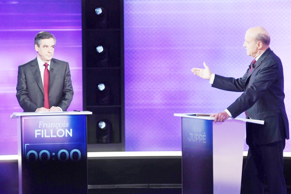 TOPSHOT - The two finalists in France's conservative presidential primary, Francois Fillon (L) and Alain Juppe, take part in the first televised debate between the two remaining candidates for the right-wing Les Republicains (LR) party primaries in Paris on November 24, 2016, ahead of the 2017 presidential election. France's conservative presidential favourite Francois Fillon struck a confident tone ahead of a final televised debate on November 24 with his rival Alain Juppe. A poll published on November 23 showed Fillon would win 65 percent of votes in the final primary vote on November 27 against 35 percent for the more centrist Juppe. / AFP / POOL / Eric FEFERBERG
