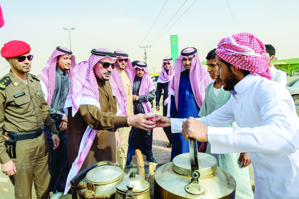 أمير القصيم يتناول شاي الجمر من أحد الشباب ببريدة.