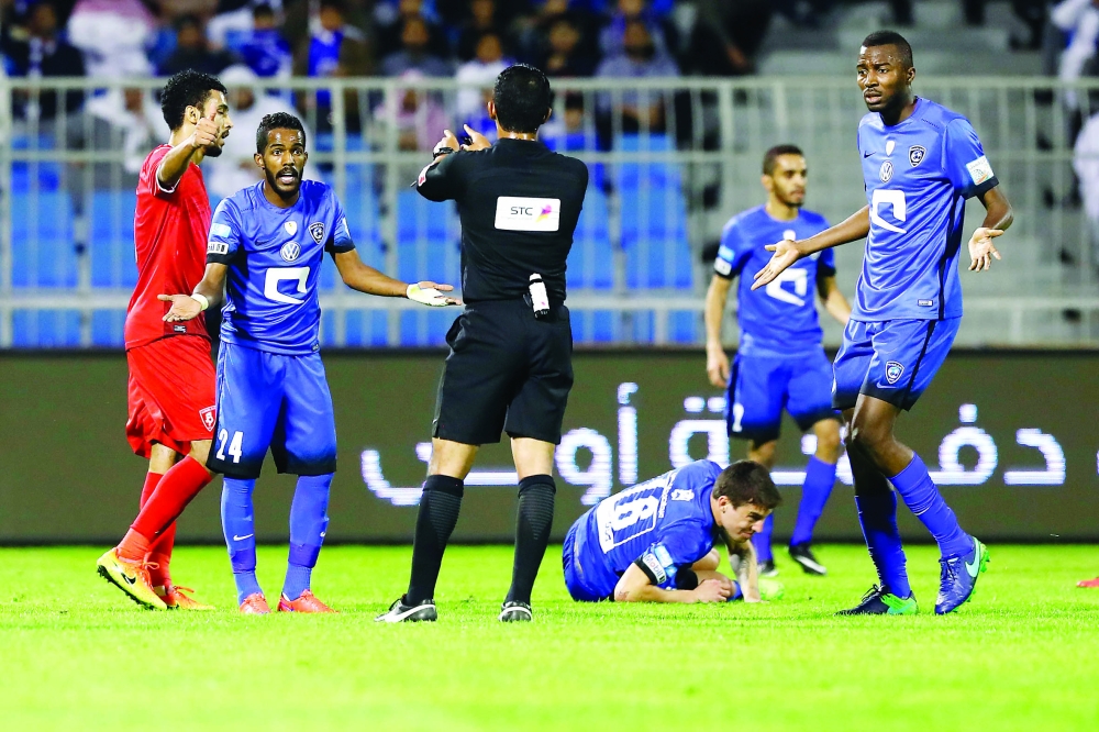 اعتراض لاعبي فريق الهلال على قرار الحكم سلطان الحربي أثناء لقاء الوحدة.