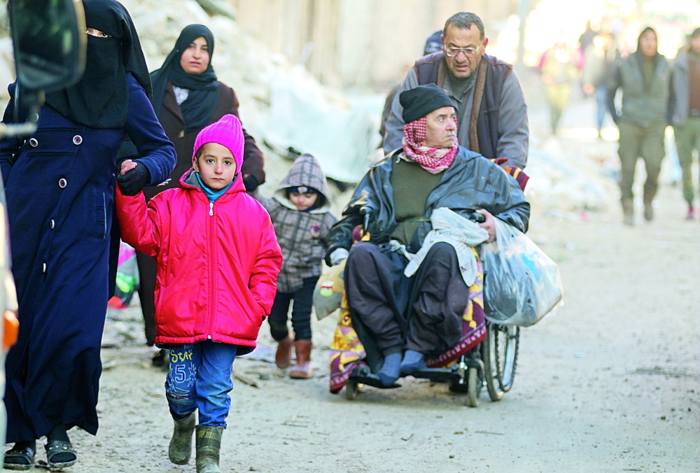 People walk as they gather to be evacuated from a rebel-held sector of eastern Aleppo, Syria December 15, 2016. REUTERS/Abdalrhman Ismail