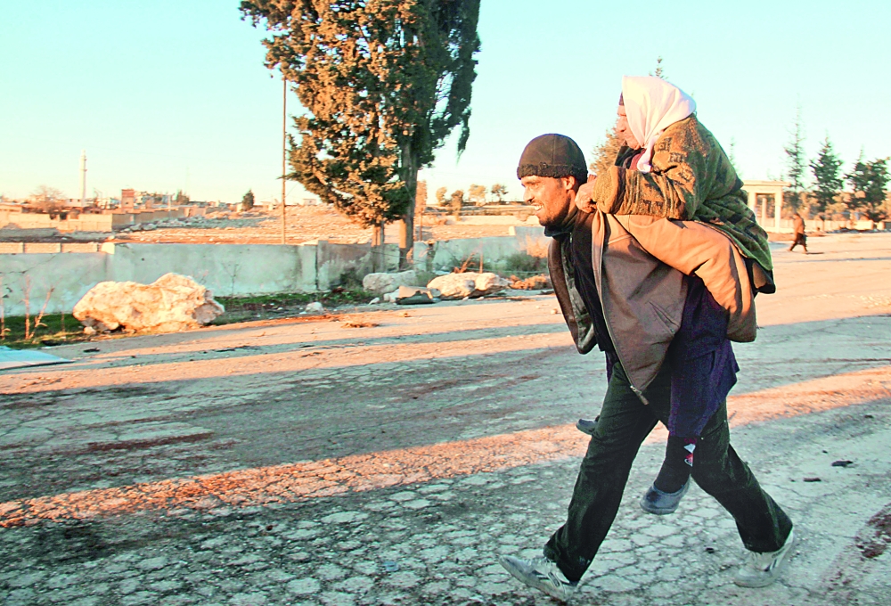 Syrians, who were evacuated from rebel-held neighbourhoods in the embattled city of Aleppo, arrive in the opposition-controlled Khan al-Aassal region, west of the city, on December 15, 2016, the first stop on their trip, where humanitarian groups will transport the civilians to temporary camps on the outskirts of Idlib and the wounded to field hospitals. A convoy carrying the first evacuees from rebel-held parts of Syria's Aleppo arrived in opposition territory west of the city on Thursday, a doctor there and a monitor said.  / AFP / Omar haj kadour
