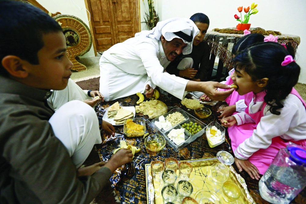 Saudi man Yazid al-Fefi has breakfast with his children before they go to their school through Fifa Mountain, in Jazan, south of Saudi Arabia, December 15, 2016. Picture take December 15, 2016. REUTERS/Mohamed Al Hwaity