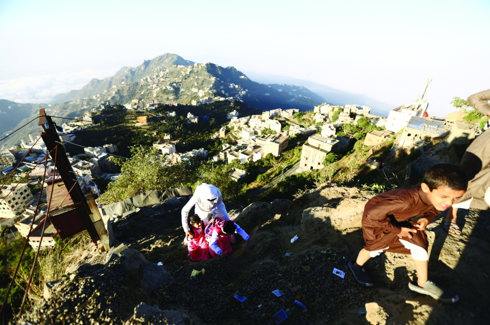 Saudi man Yazid al-Fefi help his children as they make their way to their schools through Fifa Mountain, in Jazan, south of Saudi Arabia, December 15, 2016. Picture take December 15, 2016. REUTERS/Mohamed Al Hwaity