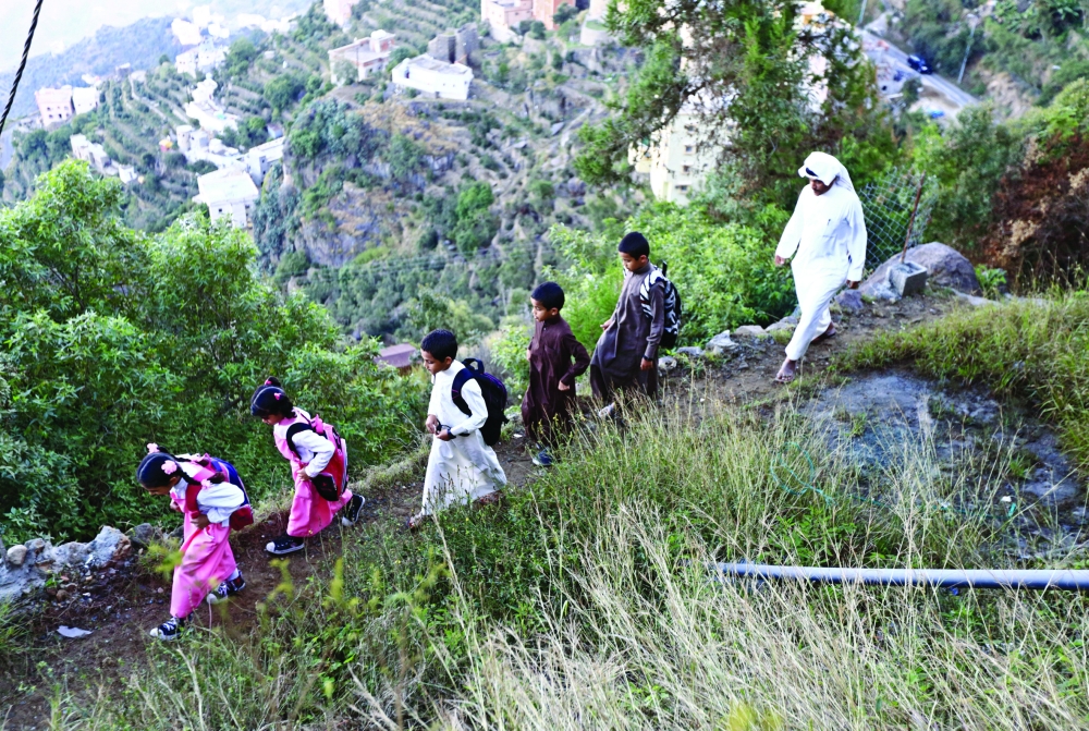 Saudi man Yazid al-Fefi walks with his children as they make their way to their schools through Fifa Mountain, in Jazan, south of Saudi Arabia, December 15, 2016. Picture take December 15, 2016. REUTERS/Mohamed Al Hwaity TPX IMAGES OF THE DAY