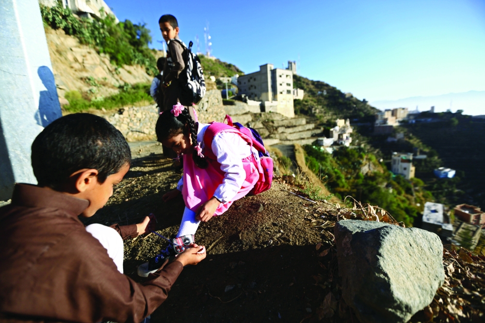 A Saudi boy of al-Fefi family helps his sister as they make their way to their schools through Fifa Mountain, in Jazan, south of Saudi Arabia, December 15, 2016. Picture take December 15, 2016. REUTERS/Mohamed Al Hwaity