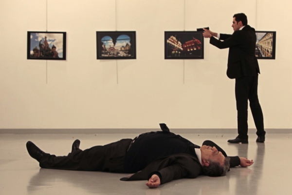 EDITORS NOTE: Graphic content / This picture taken on December 19, 2016 shows Andrey Karlov (bottom), the Russian ambassador to Ankara, lying on the floor after being shot by a gunman (R) during an attack during a public event in Ankara. A gunman crying 