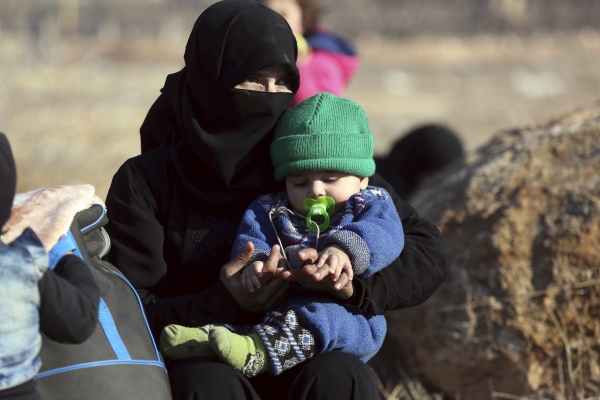 A Syrian woman holding a child who were  evacuated from the embattled Syrian city of Aleppo during the ceasefire arrive at a refugee camp in Rashidin, near Idlib, Syria, early Monday, Dec. 19, 2016. The Security Council on Monday approved the deployment of U.N. monitors to the Syrian city of Aleppo as the evacuation of fighters and civilians from the last remaining opposition stronghold resumed after days of delays. (AP Photo)