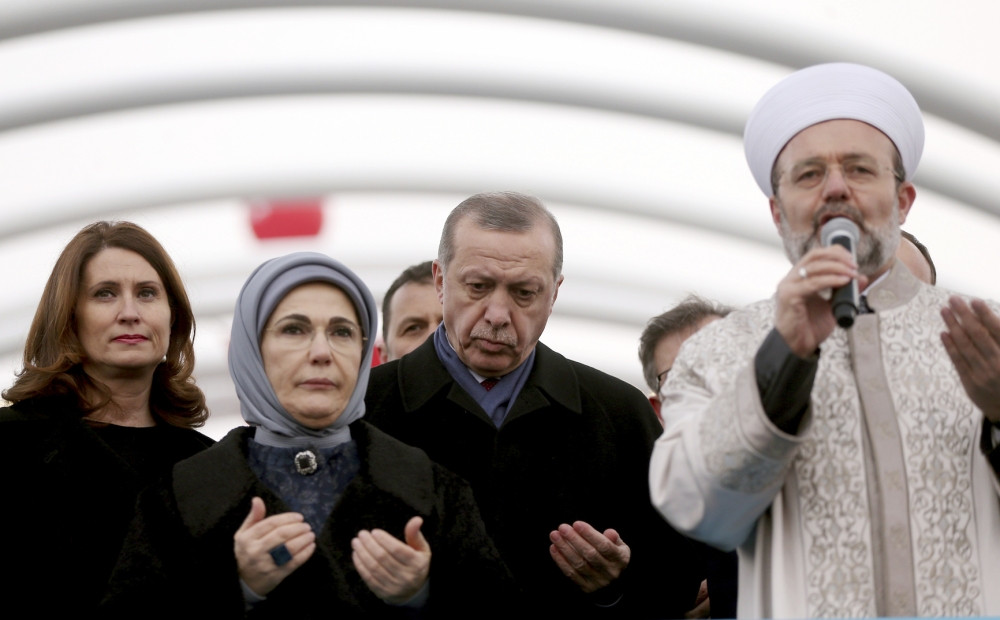 أردوغان مع زوجته خلال مشاركته في تأبين السفير الروسي أمس في أنقرة. (أ. ف. ب)