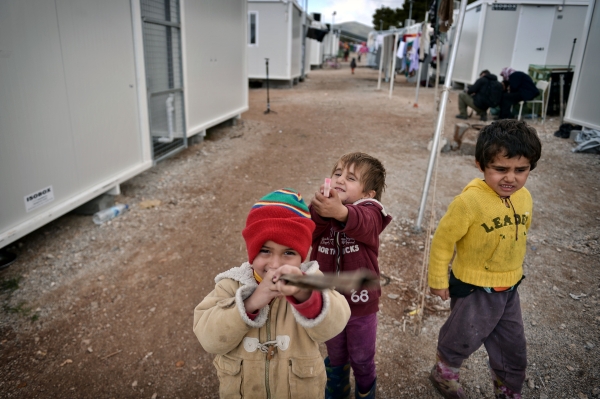 TOPSHOT - Children play in Ritsona refugee camp, some 80 km north of Athens on December 21, 2016. Before braving a 'trip of death' to escape Syria, Talal Rankoussi was a chef in a Damascus restaurant considered the largest in the world.Bawabet Al Dimashq -- Damascus Gate -- still holds that distinction in the Guinness Book of Records as it can seat over 6,000 people.So when 41-year-old Talal was asked by a US benefactor to spice up the meals for several hundred fellow Syrians at the Ritsona camp near Athens, the two-decade culinary veteran did not hesitate. / AFP / LOUISA GOULIAMAKI
