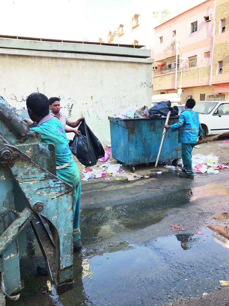 عمال البلدية يرفعون النفايات المجاورة للمدرسة.