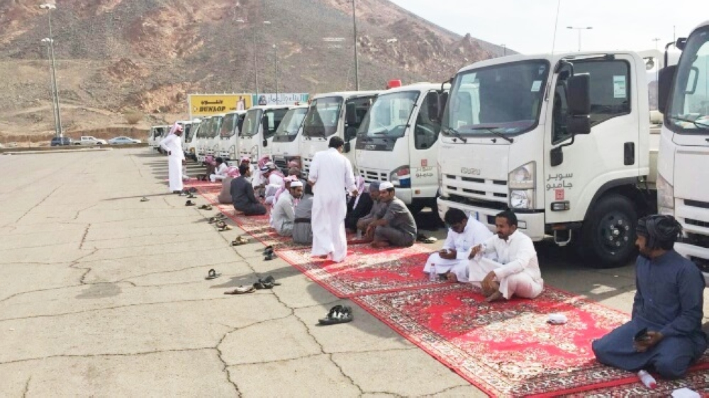 سائقون خلال تجمعهم في مواقف الاستاد بالمدينة المنورة أمس.  (عكاظ)