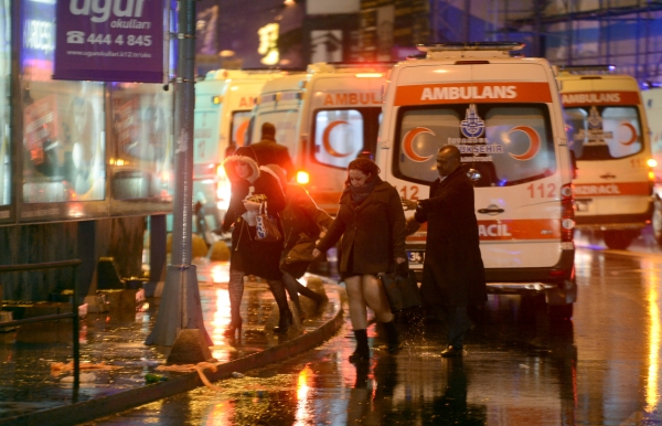 People flee as ambulances are on the attack site on January 1, 2017 in Istanbul. At least two people were killed in an armed attack Saturday on an Istanbul nightclub where people were celebrating the New Year, Turkish television reports said. / AFP / IHLAS NEWS AGENCY / IHLAS NEWS AGENCY 