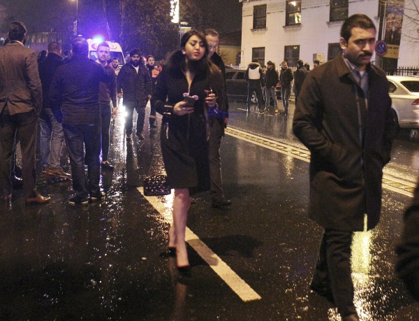 People leave the nightclub, the scene of an attack in Istanbul, early Sunday, Jan. 1, 2017. An assailant believed to have been dressed in a Santa Claus costume and armed with a long-barrelled weapon, opened fire at a nightclub in Istanbul's Ortakoy district during New Year's celebrations, killing dozens of people and wounding dozens of others in what the province's governor described as a terror attack.(DHA-Depo Photos via AP)