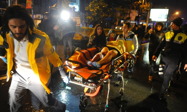 TOPSHOT - First aid officers carry an injured woman at the site of an armed attack on January 1, 2017 in Istanbul. At least two people were killed in an armed attack Saturday on an Istanbul nightclub where people were celebrating the New Year, Turkish television reports said. / AFP / IHLAS NEWS AGENCY / IHLAS NEWS AGENCY
