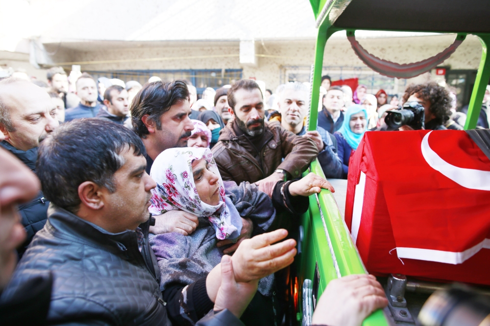 A relative tries to reach out to the Turkish flag-draped coffin of Fatih Cakmak, one of the victims of the attack at a nightclub on New Year's Day, during the funeral in Istanbul, Monday, Jan. 2, 2017. Turkey's state-run news agency says police have detained eight people in connection with the Istanbul nightclub attack. The gunman, who escaped after carrying out the attack, wasn't among the eight. The Islamic State group has claimed responsibility for the attack, which killed 39 people, most of them foreigners. (AP Photo/Emrah Gurel)