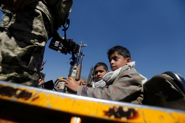 Boys hold rifles as they ride on the back of a military truck during a parade held by newly recruited Houthi fighters in Sanaa, Yemen, January 1, 2017. REUTERS/Khaled Abdullah