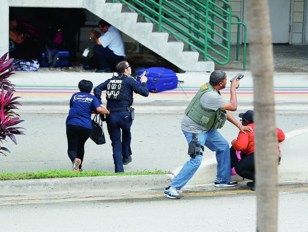 FORT LAUDERDALE, FL - JANUARY 06: Police assist people seeking cover outside Terminal 2 of Fort Lauderdale-Hollywood International airport after a shooting took place near the baggage claim on January 6, 2017 in Fort Lauderdale, Florida. Officials are reporting that five people wear killed and eight wounded in an attack from a single gunman.   Joe Raedle/Getty Images/AFP
== FOR NEWSPAPERS, INTERNET, TELCOS & TELEVISION USE ONLY ==
