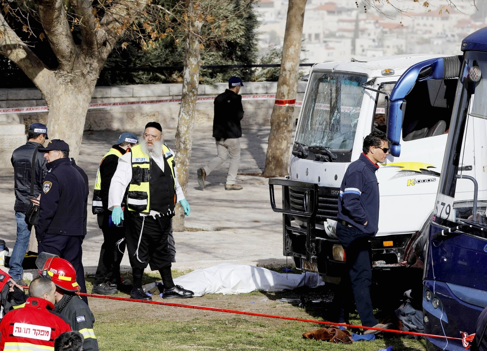 Israeli security forces and emergency personnel gather at the site of a vehicle-ramming attack in Jerusalem on January 8, 2017. / AFP / MENAHEM KAHANA
