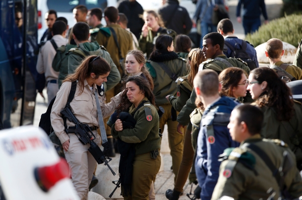 An Israeli soldier is consoled as she cries at the site of a vehicle-ramming attack in Jerusalem on January 8, 2017. A truck ploughed into a group of soldiers in Jerusalem on in which a number of people were injured.

 / AFP / AHMAD GHARABLI
