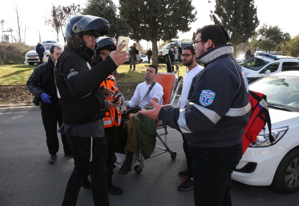 Israeli security forces and medics help evacuate a wounded soldier at the site of a ramming attack in Jerusalem on January 8, 2017. A truck ploughed into a group of soldiers in Jerusalem on in which a number of people were injured.

 / AFP / Gali Tibbon
