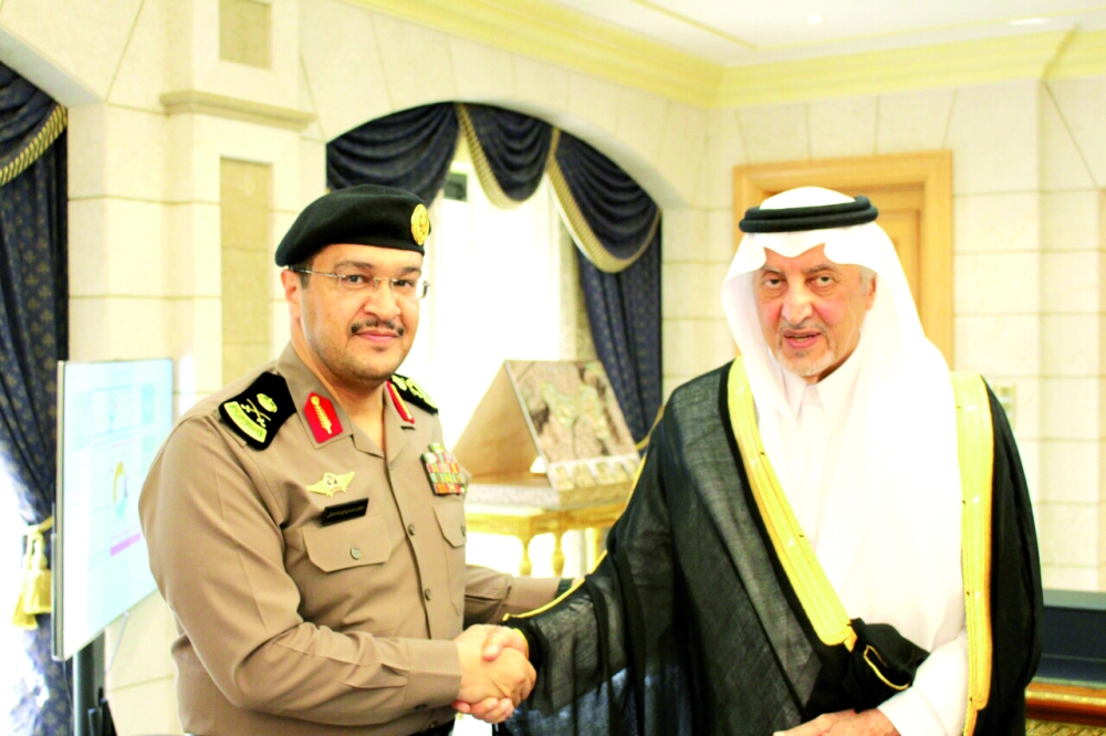 ‏الأمير خالد الفيصل مهنئا اللواء محمد الحارثي بعد تقليده الرتبة الجديدة. (عكاظ)