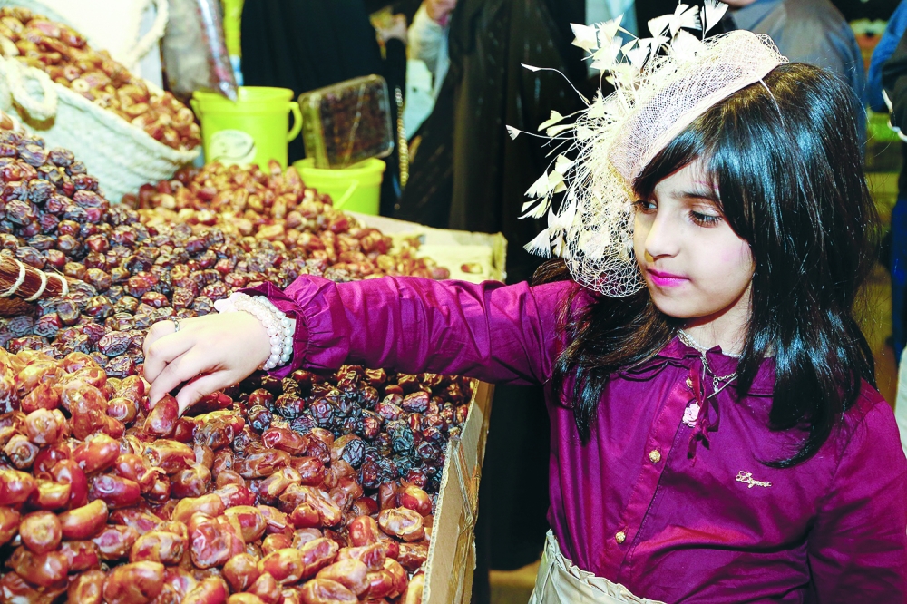 





طفلة تجرب أحد أنواع التمور المعروضة في المهرجان. 