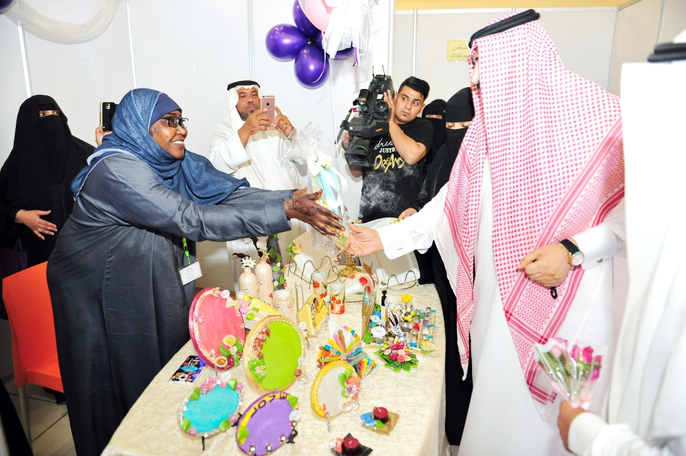 مستفيدة من الضمان تهدي مدير فرع وزارة العمل والتنمية الاجتماعية بعض أعمالها. (تصوير: أحمد القحطاني)