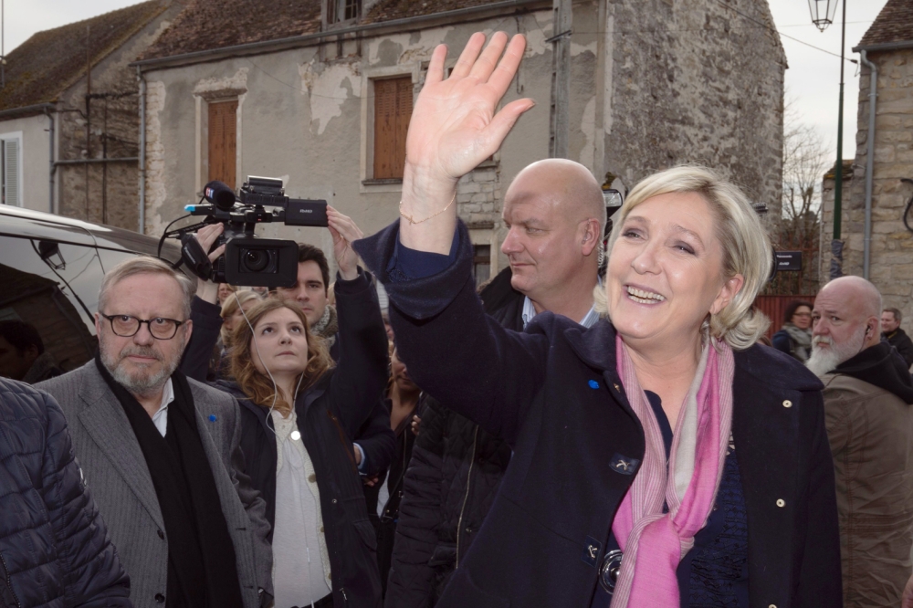 French presidential election candidate for the far-right Front National (FN) party Marine Le Pen waves as she arrives in Le Vaudoue to collect the city's mayor sponsorship commitment after he withdrew it to Francois Fillon to gave it to her, on March 3, 2017 in Le Vaudoue. Anyone wishing to run for French president must first gather 500 “sponsors” among France’s 47,000-odd mayors and other elected officials. / AFP / JOEL SAGET
