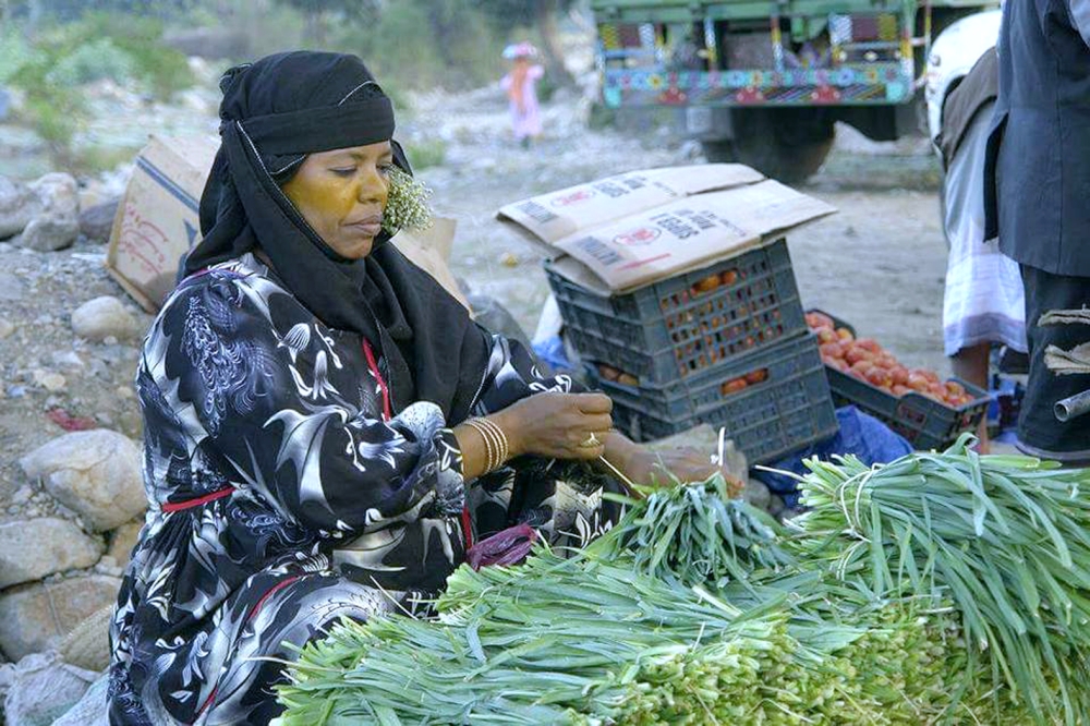 يمنية تبيع الخضراوات في سوق الضباب في تعز.   (متداولة)