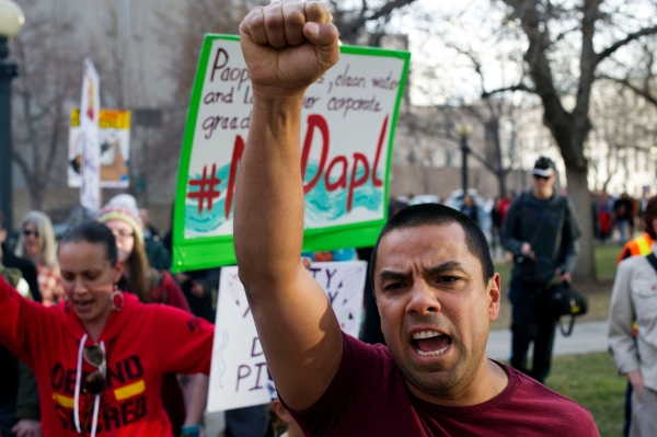 Native Americans and indigenous rights activists march and hold up signs in protest during a Native Nations March in Denver, Colorado on March 10, 2017. Native tribes from around the US gathered for four days of protest against the administration of US President Donald Trump and the Dakota Access oil pipeline. In the first week of his presidency, Donald Trump signed executive orders to revive the Dakota Access project, along with a second pipeline put on hold by the Obama administration, Keystone XL.  / AFP / Jason Connolly
