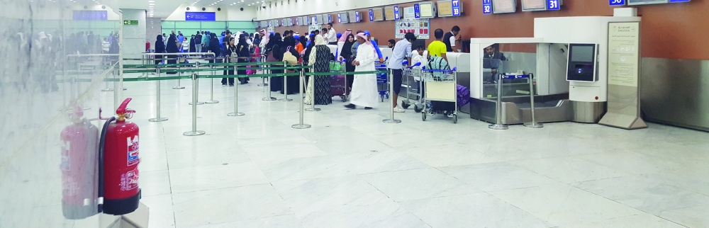 مسافرون ينهون إجراءات سفرهم في مطار الملك عبدالعزيز في جدة أمس الأول. (تصوير: المحرر)