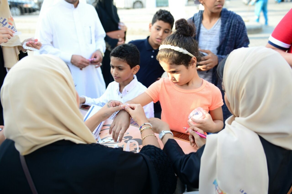 طفلة خلال ارتدائها الإسورة في مهرجان «أتاريك» بجدة. (عكاظ)