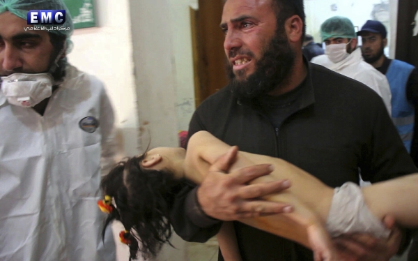 FILE -- This Tuesday April 4, 2017, file photo, provided by the Syrian anti-government activist group Edlib Media Center, that is consistent with independent AP reporting, shows a man carrying a child following a suspected chemical attack, at a makeshift hospital in the town of Khan Sheikhoun, northern Idlib province, Syria. Walid Moallem, Syria's Foreign Minister, told reporters Thursday, April 6, 2017, that it didn't use chemical weapons in Tuesday's attack, and he blamed the rebels for stockpiling the deadly substance. (Edlib Media Center, via AP, File)