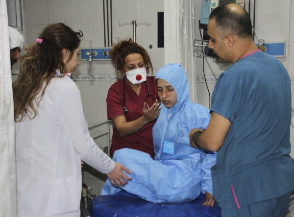 In this photo taken on late Tuesday, April 4, 2017 and made available Wednesday, April 5, Turkish medics check a victim of alleged chemical weapons attacks in Syrian city of Idlib, at a local hospital in Reyhanli, Hatay, Turkey.  A suspected chemical attack in a town in Syria's rebel-held northern Idlib province killed dozens of people on Tuesday, opposition activists said, describing the attack as among the worst in the country's six-year civil war.(IHA via AP)