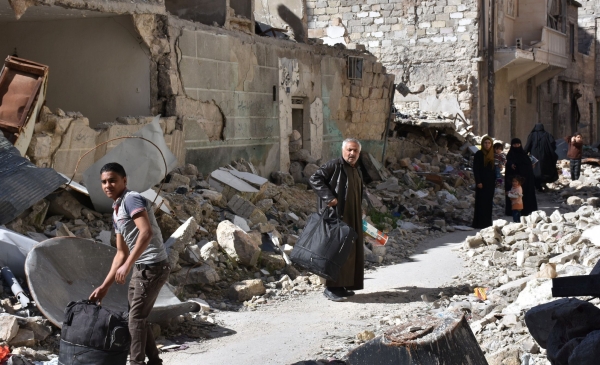 Syrians, who fled their hometown due to the fighting, carry their belongings upon their return to Aleppo's Myassar neighbourhood on April 5, 2017.   / AFP / George OURFALIAN
