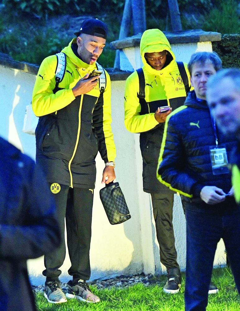 Dortmund players check their smartphones outside the team bus after it was damaged in an explosion before the Champions League quarterfinal soccer match between Borussia Dortmund and AS Monaco in Dortmund, western Germany, Tuesday, April 11, 2017.  (AP Photo/Martin Meissner)