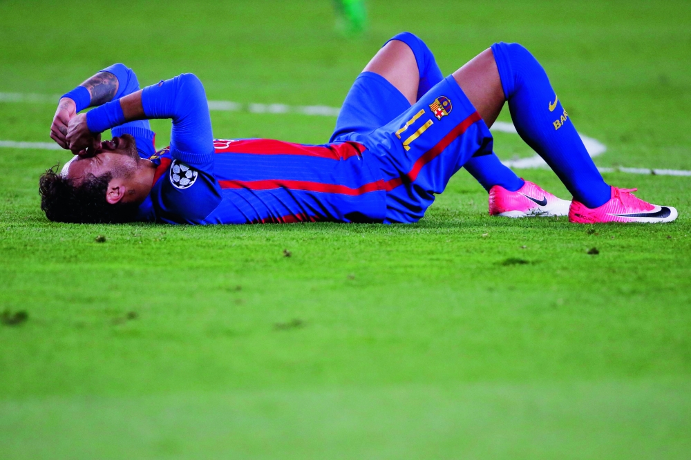 Barcelona's Brazilian forward Neymar lies on the field during the UEFA Champions League quarter-final second leg football match FC Barcelona vs Juventus at the Camp Nou stadium in Barcelona on April 19, 2017. / AFP / Marco BERTORELLO
