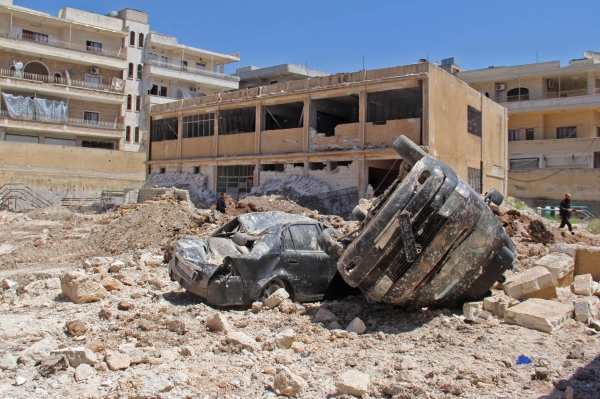 Wrecked vehicles are seen amidst debris following air strikes on the rebel-held village of Kafr Tekharim in northwest Syria early on April 25, 2017 in which 12 people were killed 12 people and put a nearby field clinic out of service.  / AFP / Omar haj kadour
