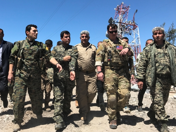 A U.S. military commander (2nd R) walks with Kurdish fighters from the People's Protection Units (YPG) at the YPG headquarters that was hit by Turkish airstrikes in Mount Karachok near Malikiya, Syria April 25, 2017. REUTERS/Rodi Said