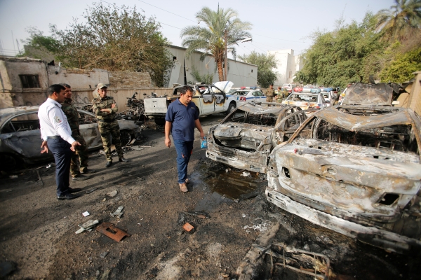 Members of Iraqi security forces look at the site after a suicide car bomb attack in Baghdad, Iraq April 29, 2017. REUTERS/Khalid al Mousily TPX IMAGES OF THE DAY