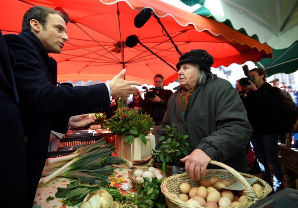 French presidential election candidate for the En Marche ! movement Emmanuel Macron (L) speaks with a woman on April 29, 2017 on a market in Poitiers, central France, while campaigning ahead of the second and final round of the presidential elections which takes place on May 7. / AFP / POOL / Eric FEFERBERG
