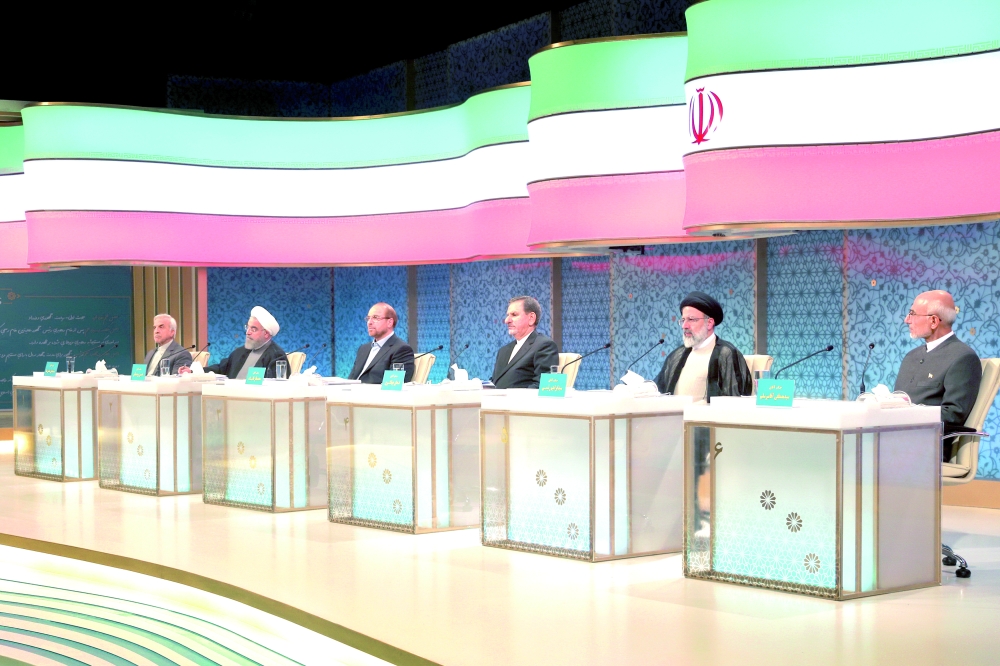 In this photo released by the Islamic Republic of Iran Broadcasting on Friday, April 28, 2017, presidential candidates from right, Mostafa Mirsalim, Ebrahim Raisi, Eshagh Jahangiri, Mohammad Bagher Qalibaf, Hassan Rouhani and Mostafa Hashemitaba, attend a TV debate in a state-run TV studio, in Tehran, Iran. Tehran's mayor and presidential candidate Mohammad Bagher Qalibaf has accused President Hassan Rouhani's administration of dishonesty, mismanagement and supporting the rich at the expense of the poor in the first debate between the six presidential candidates.  (Mehdi Dehghan/Islamic Republic of Iran Broadcasting via AP)