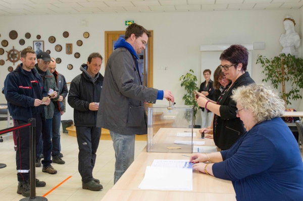 Deputy Mayor Joanne Briand (2nd R) checks a voter's ID during the second round of the French presidential election at a polling station at the City Hall of Saint-Pierre, on the French archipelago of Saint Pierre and Miquelon, on May 6, 2017.  / AFP / Chantal Briand
