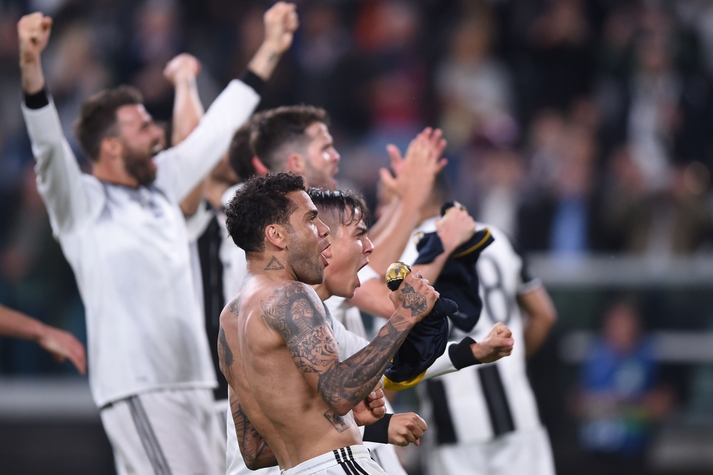 Juventus' forward from Argentina Paulo Dybala (C) and Juventus Defender from Brazil Dani Alves celebrate with teammates at the end of the UEFA Champions League semi final second leg football match Juventus vs Monaco, on May 9, 2017 at the Juventus stadium in Turin.  Juventus secured their place in the final of the Champions League on Tuesday after beating Monaco 2-1 in their semi-final second leg to win the tie 4-1 on aggregate. / AFP / FILIPPO MONTEFORTE
