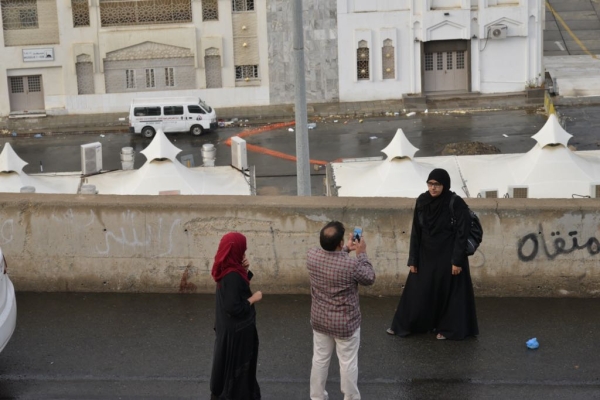 مقيم يلتقط صورا لعائلته مع الأمطار. (تصوير: حسن القربي hh22n@)